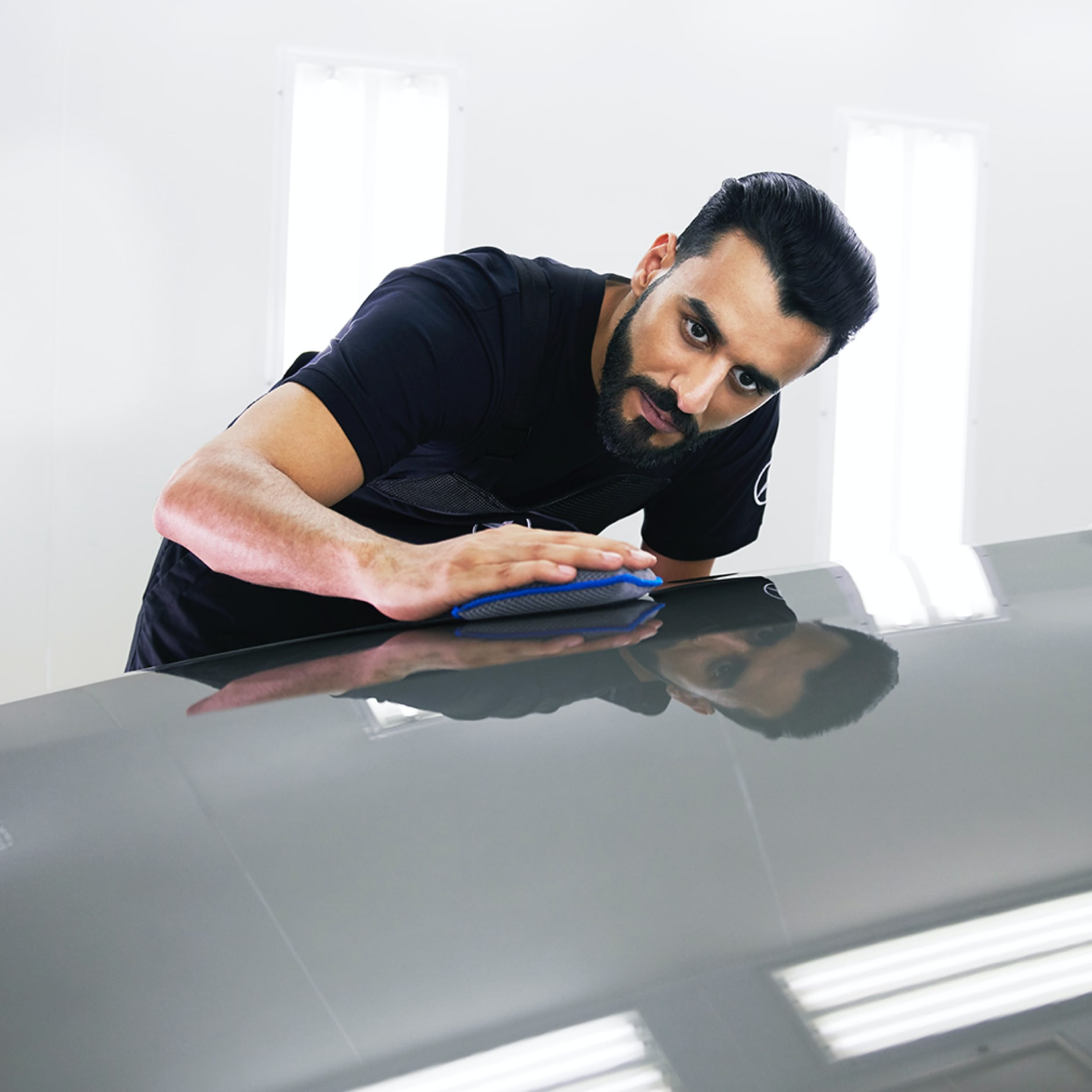 SmallRepair A Mercedes-Benz technician checks the bonnet for minor damage.