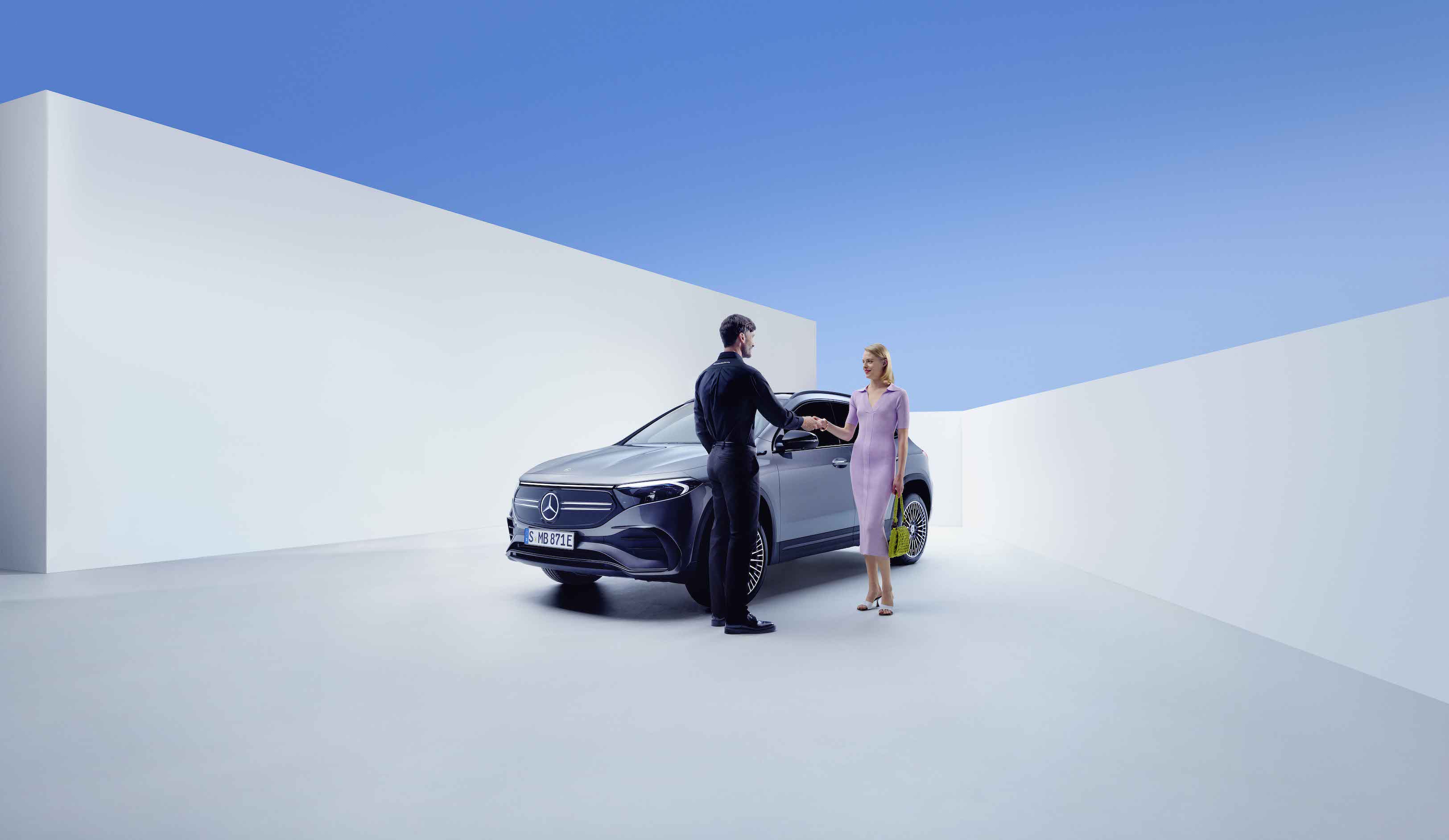 Mercedes-Benz Service Contracts A man and a woman shake hands in front of a Mercedes-Benz.